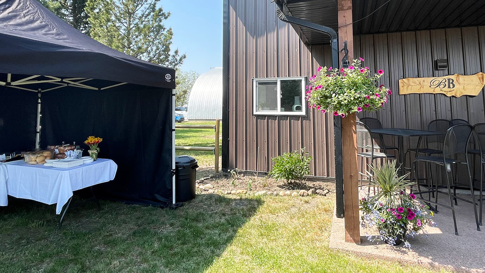 Beau Bella Winery outdoor patio with hanging flower baskets and showing a corner of the clubhouse